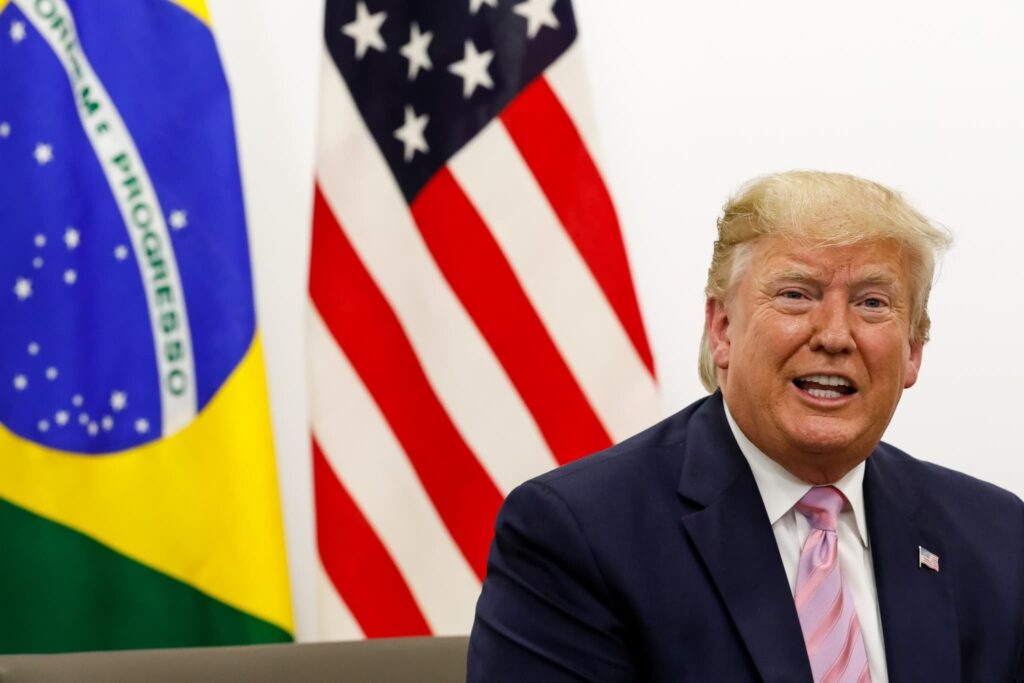 trump com as bandeiras de Brasil e EUA